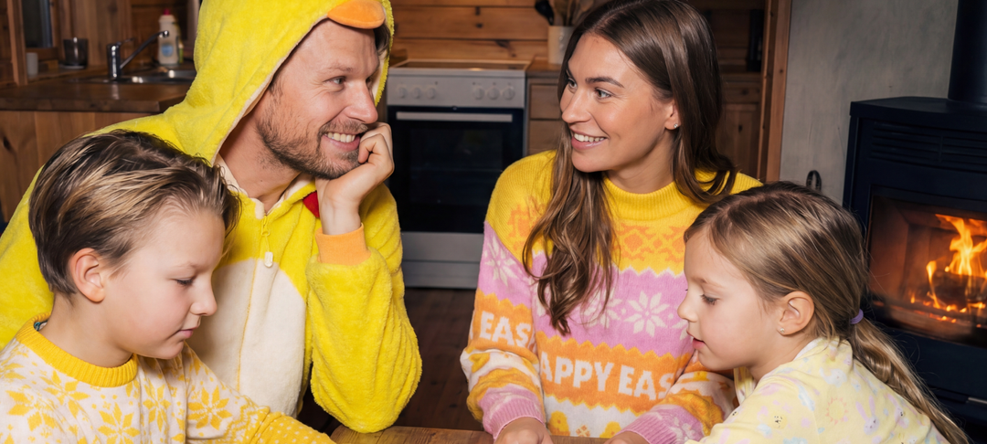 Family in yellow Easter sweaters and duck costume sitting together by a fireplace, ready for an Easter quiz